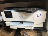 une imprimante posée sur une étagère, à côté d'un clavier
