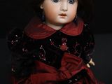 a close up of a doll in a red dress on a black background