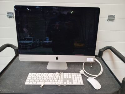 un ordinateur posé sur un bureau, avec un clavier et une souris
