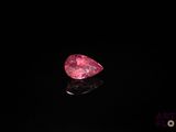 gros plan d'un diamant rose sur une surface noire