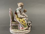 a figurine of a woman holding a baby and a dog