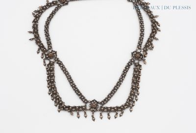 une photo en gros plan d'un collier posé sur une surface blanche