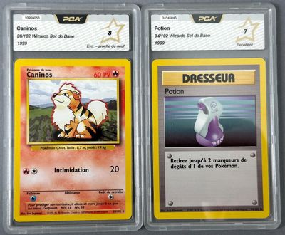 two pokemon cards are shown in plastic cases on a table