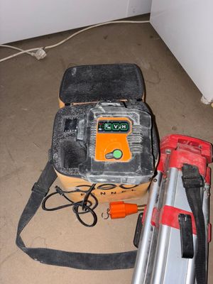 une photo montrant un sac à outils et une cloueuse filaire posés par terre
