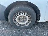 une camionnette blanche qui a un pneu crevé