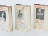 trois livres sont alignés sur une surface blanche