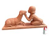 une statue représentant un enfant et un mouton posée sur une table