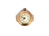une petite horloge en or dont le cadran est orné de chiffres romains