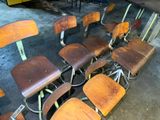 many wooden chairs that are lined up in a room