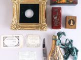 une photo représentant un cadre, une bouteille de vin et d'autres objets posés sur une table