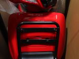 un scooter rouge qui se trouve dans une boîte