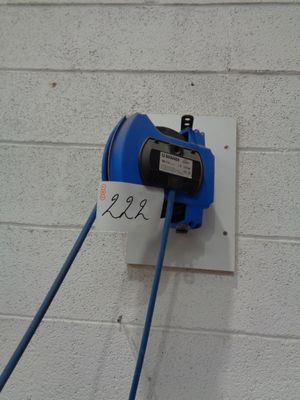 a blue cord plugged into a wall with a sign on it