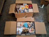 une boîte en carton remplie de livres et de magazines posée par terre