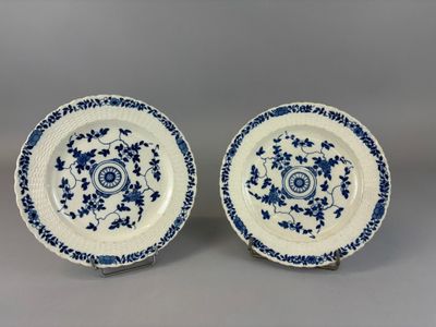 a pair of blue and white plates with floral designs