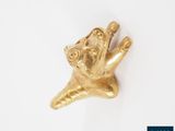une image représentant une figurine en or posée sur une surface blanche