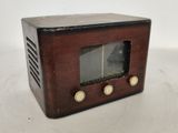 une radio à l'ancienne posée sur une surface blanche