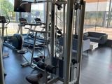 a gym room with machines and a television in it