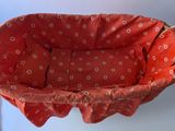 a red baby seat with a polka dot pattern on it