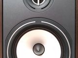 a close up of a speaker on a wooden surface