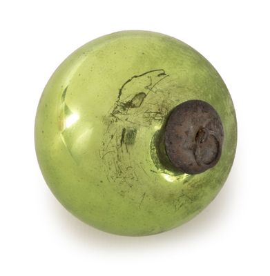 a green apple with a hole in it on a white surface