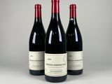 trois bouteilles de vin rouge posées côte à côte sur une table