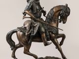 statue représentant un homme à cheval, sur laquelle est posée une épée