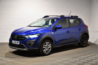une voiture bleue garée dans un garage au sol en damier