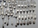 many spoons and forks laid out on a table