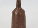 a brown vase that is sitting on a white surface