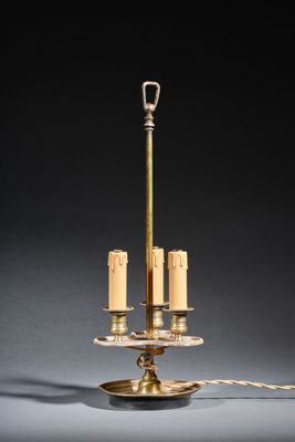an antique brass table lamp with three candles on a stand