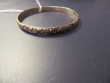 a silver bracelet that is on top of a table