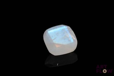 une image représentant une pierre oplite blanche sur une surface noire
