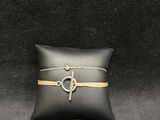 a black pillow with a gold chain and a silver cross on it