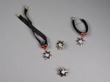 three pieces of jewelry on a table with a ribbon around them