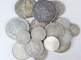 a pile of silver and silver coins on a white surface
