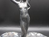 an image of a silver figurine of a woman on a leaf shaped tray