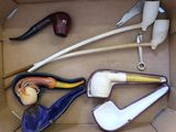 une boîte contenant de nombreux types de pipes à fumer