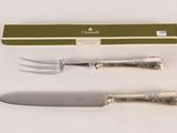 two forks and a knife on a white table
