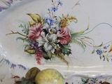 a plate with flowers and fruit on it on a table