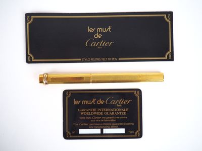 a gold pen and a black business card on a white surface