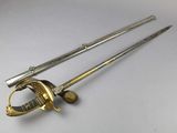 two swords with a gold handle on a white surface