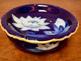 a blue bowl with white flowers on it sitting on a table
