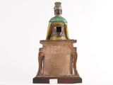 statue of a man sitting on a pedestal with a crown on top of his head