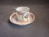 a small cup and saucer sitting on a table