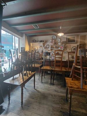 tables and chairs are lined up in a room with a large window