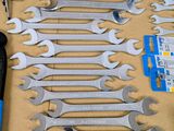 many wrenches and other tools laid out on a table