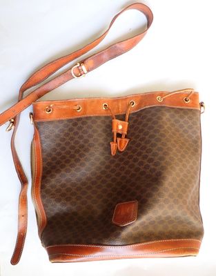sac à main marron et beige, avec des anses en cuir marron sur un fond blanc
