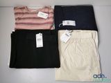 three pairs of women ' s pants with tags on them sitting on a table
