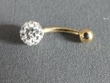 a close up of a gold belly ring with a crystal ball