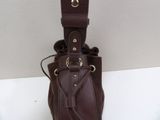 brown leather purse with gold hardware and strap on a white surface